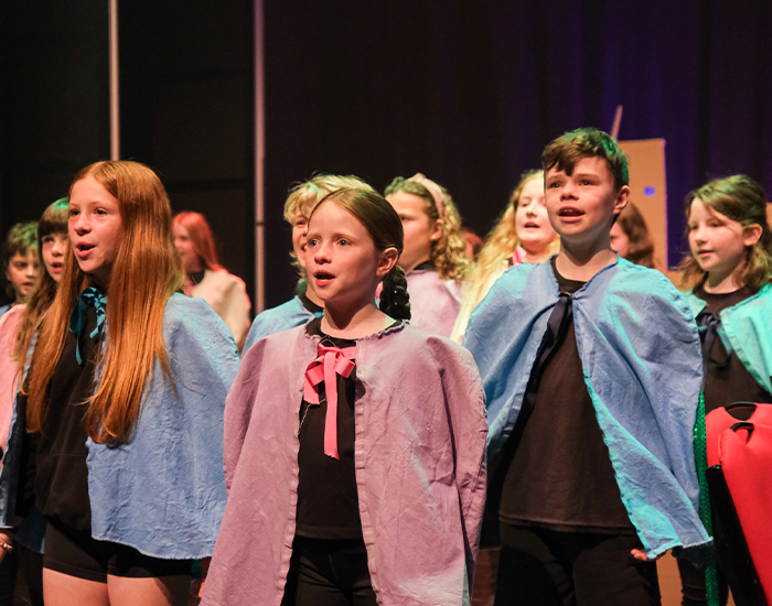 Children dancing on the stage while perfoming a scene in Gris